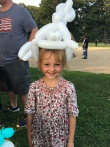 Little girl with fancy balloon crown.